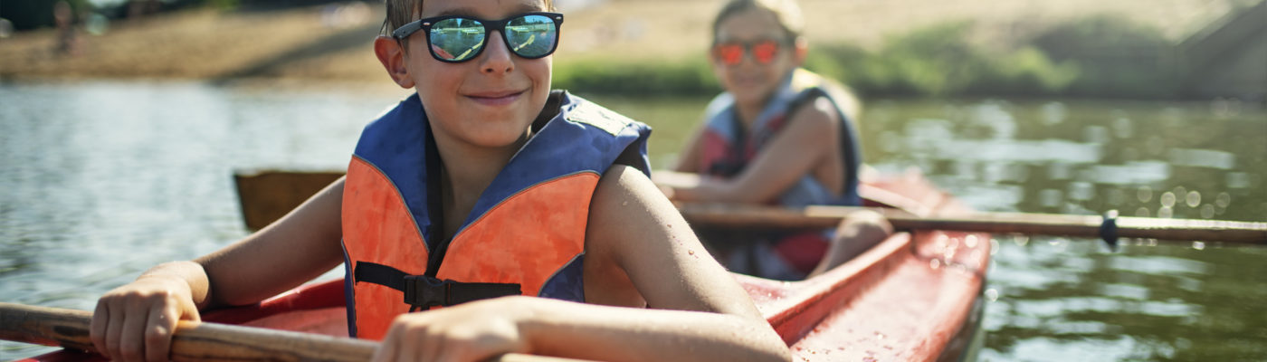 Two Boys Enjoying Kayaking On Lake