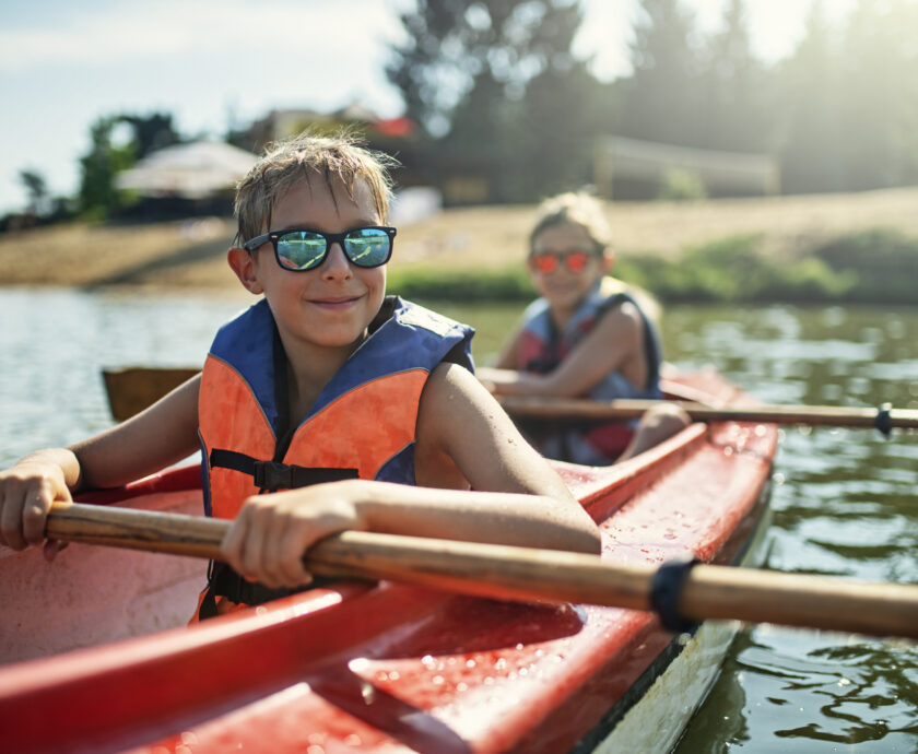 Two Boys Enjoying Kayaking On Lake