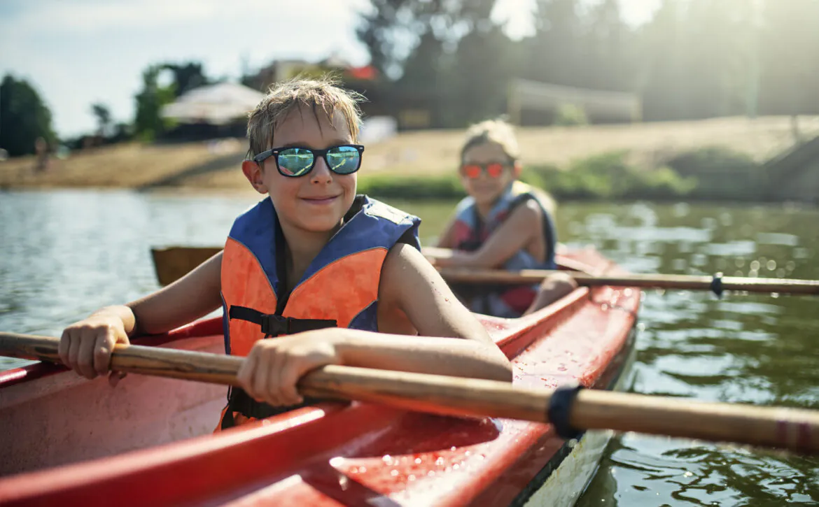 Two Boys Enjoying Kayaking On Lake